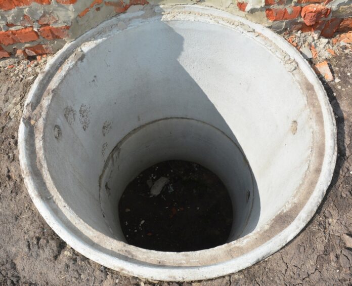 Concrete septic tank. Sewer tank hole installation outdoors